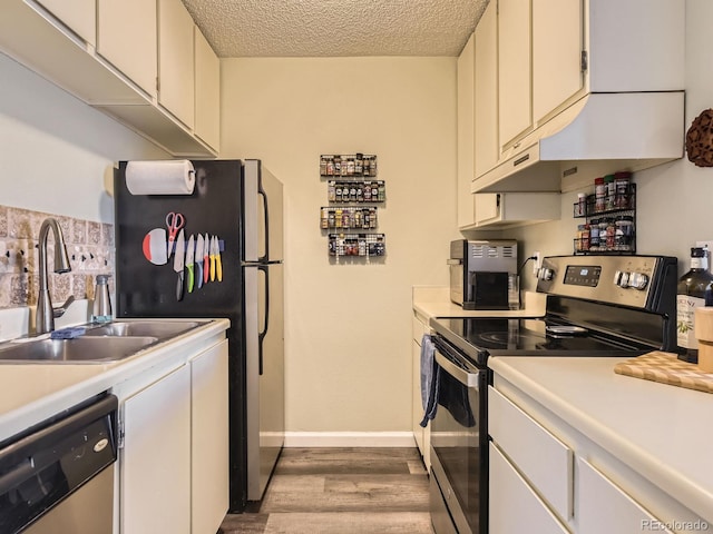 kitchen featuring sink, a textured ceiling, white cabinets, and stainless steel appliances