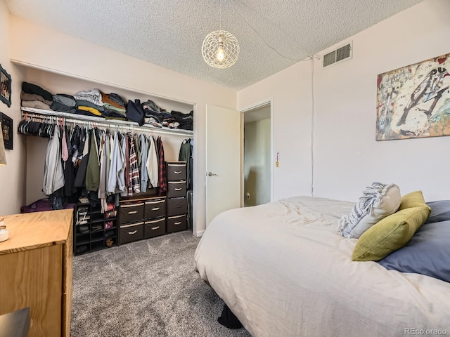 bedroom with a textured ceiling, a closet, and dark carpet