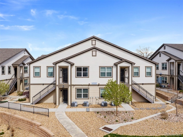 view of front of property with central AC, stairway, and fence
