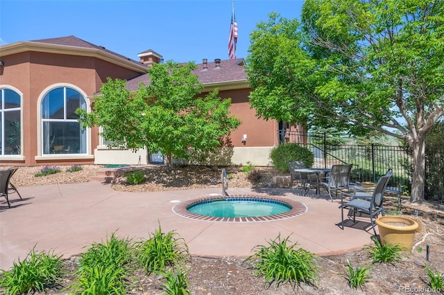 view of swimming pool featuring fence, a patio area, and an in ground hot tub
