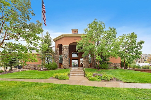 view of front of home featuring stone siding and a front yard