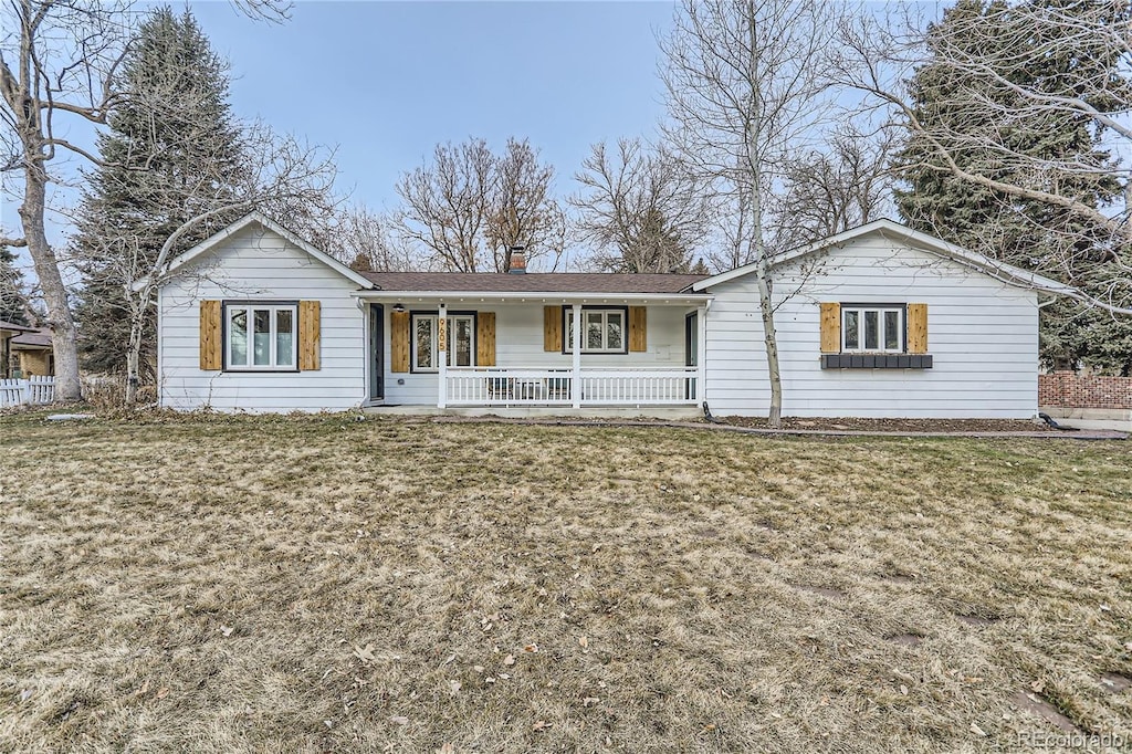 single story home featuring covered porch and a front yard