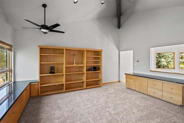 interior space featuring ceiling fan, high vaulted ceiling, light carpet, and beam ceiling