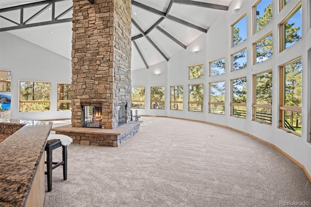 unfurnished sunroom with a stone fireplace and beam ceiling