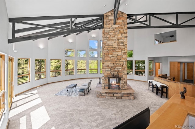 interior space with beam ceiling, a wealth of natural light, high vaulted ceiling, and carpet flooring