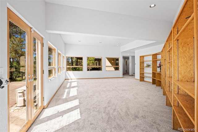 unfurnished living room with built in features, french doors, and carpet flooring