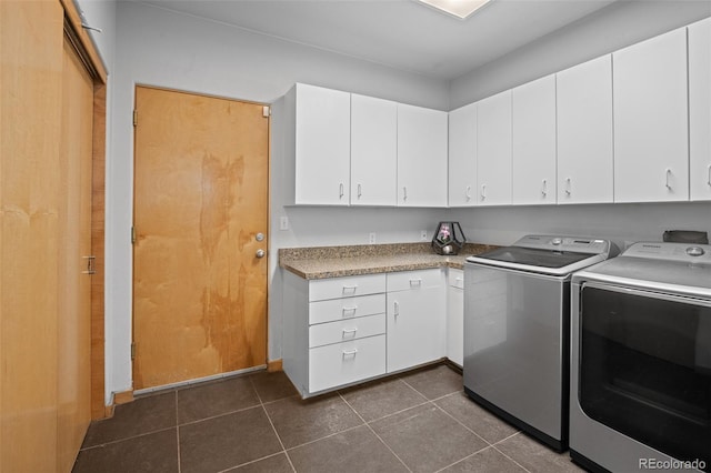 laundry area featuring cabinets, washer and dryer, and dark tile patterned flooring