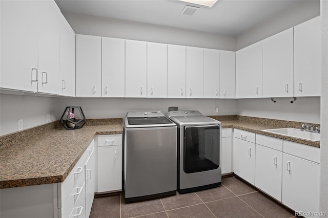 laundry area featuring cabinets, separate washer and dryer, sink, and dark tile patterned floors