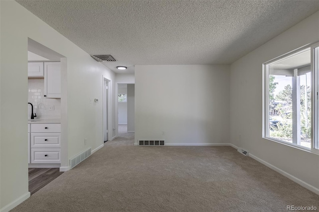 2120 S Ouray St, Aurora, CO 80013 - spare room featuring light colored carpet, a textured ceiling, and baseboards