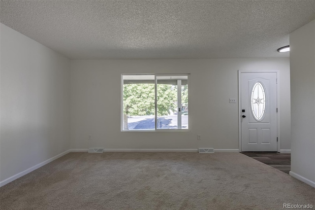 2120 S Ouray St, Aurora, CO 80013 - entryway featuring carpet floors, healthy amount of natural light, a textured ceiling, and baseboards
