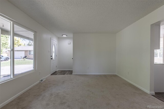 2120 S Ouray St, Aurora, CO 80013 - carpeted spare room with healthy amount of natural light, a textured ceiling, and baseboards