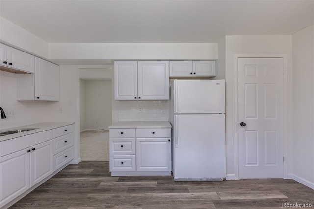 2120 S Ouray St, Aurora, CO 80013 - kitchen with freestanding refrigerator, a sink, white cabinetry, tasteful backsplash, and light countertops
