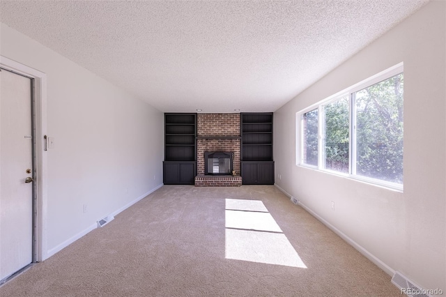 2120 S Ouray St, Aurora, CO 80013 - unfurnished living room featuring a textured ceiling, built in features, carpet flooring, a fireplace, and baseboards