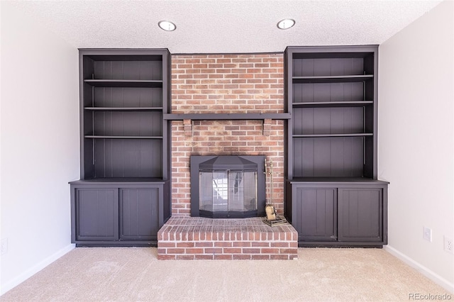 2120 S Ouray St, Aurora, CO 80013 - unfurnished living room featuring a textured ceiling, carpet, built in features, baseboards, and a brick fireplace