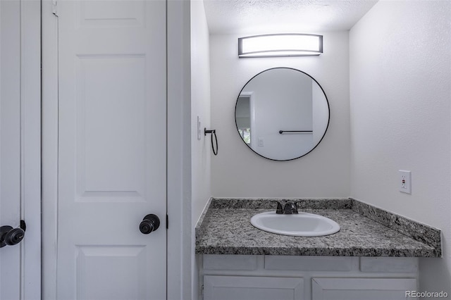 2120 S Ouray St, Aurora, CO 80013 - bathroom with vanity and a textured ceiling