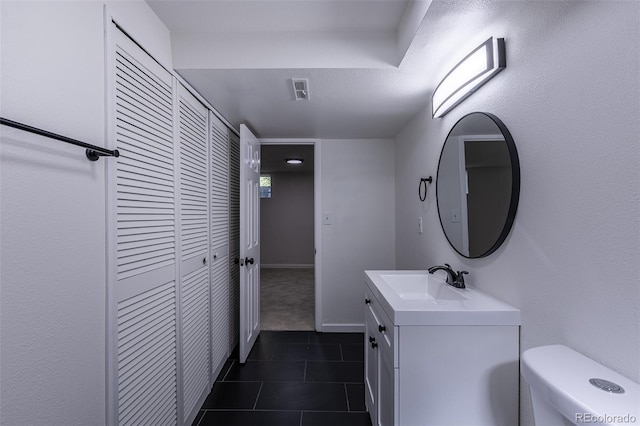 2120 S Ouray St, Aurora, CO 80013 - bathroom with vanity, toilet, and tile patterned flooring