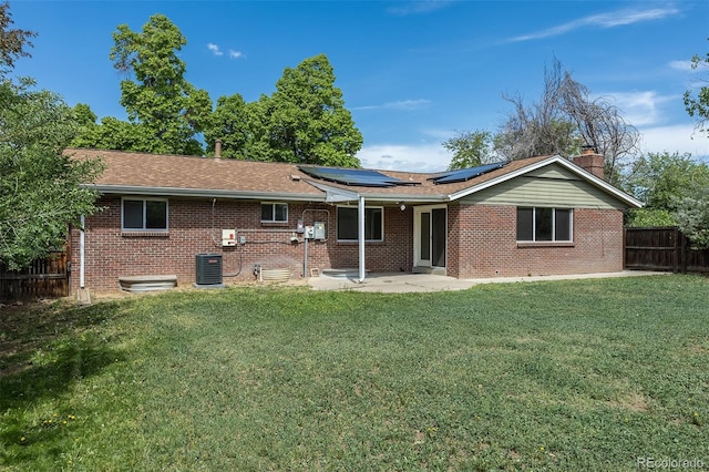 2120 S Ouray St, Aurora, CO 80013 - rear view of property with solar panels, a patio area, brick siding, central AC unit, and a chimney