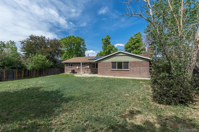 2120 S Ouray St, Aurora, CO 80013 - back of property featuring solar panels, a patio, and brick siding
