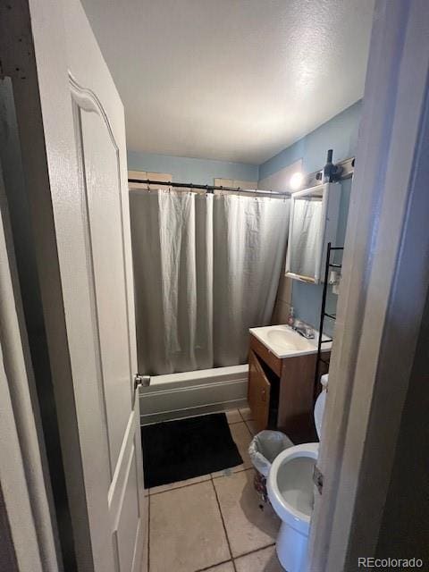 full bathroom featuring tile patterned flooring, vanity, toilet, and shower / bath combo with shower curtain