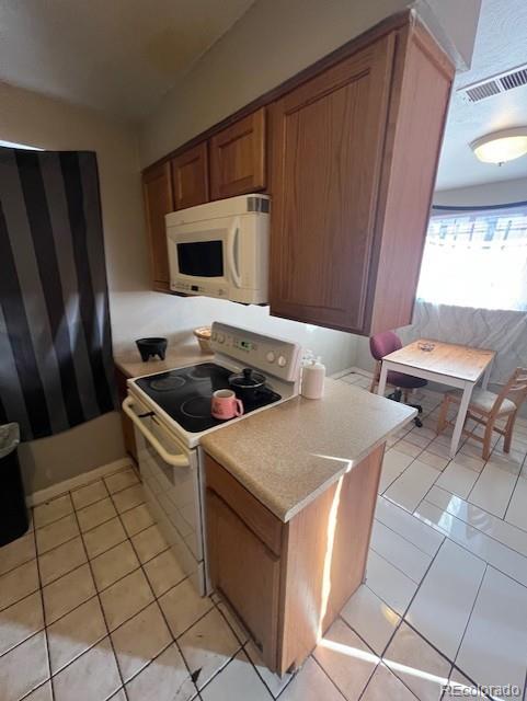 kitchen featuring light tile patterned floors and white appliances