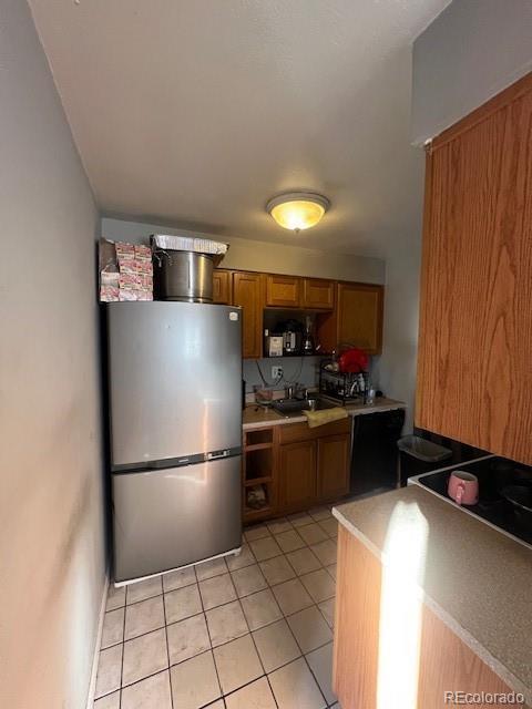 kitchen featuring stainless steel fridge, sink, and light tile patterned floors