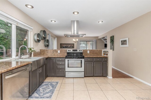 7762 W Ottawa Pl, Littleton, CO 80128 - kitchen with stainless steel appliances, island exhaust hood, a peninsula, light stone countertops, and light tile patterned flooring