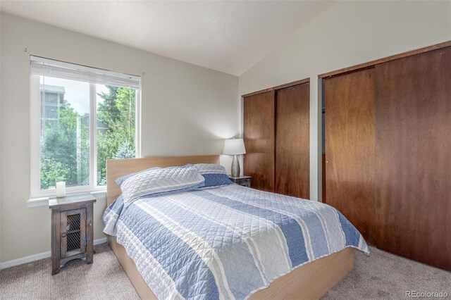 7762 W Ottawa Pl, Littleton, CO 80128 - bedroom with two closets, light carpet, and vaulted ceiling