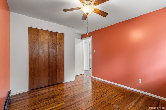 unfurnished bedroom featuring ceiling fan, dark wood-type flooring, and a closet