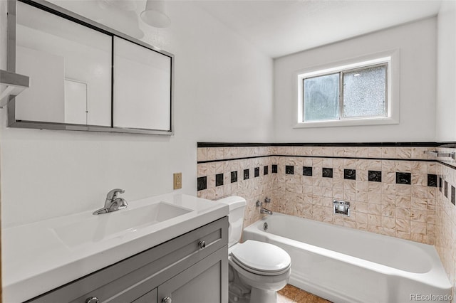 bathroom featuring a washtub, vanity, toilet, and tile walls