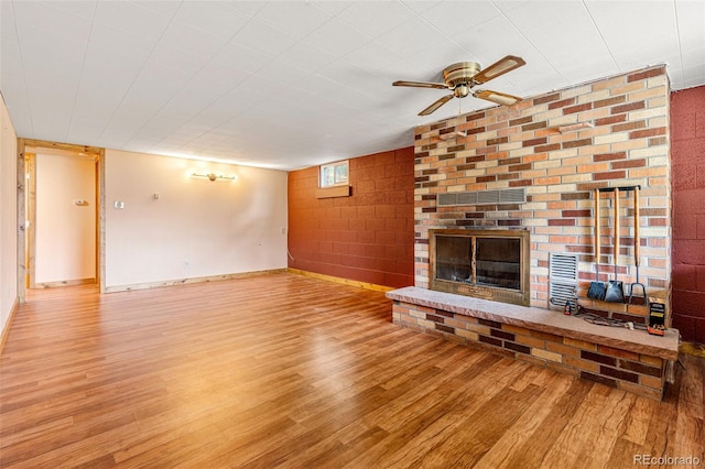 unfurnished living room with a fireplace, wood-type flooring, and ceiling fan