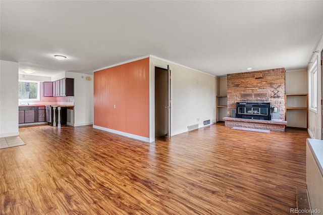 unfurnished living room featuring a stone fireplace and hardwood / wood-style floors