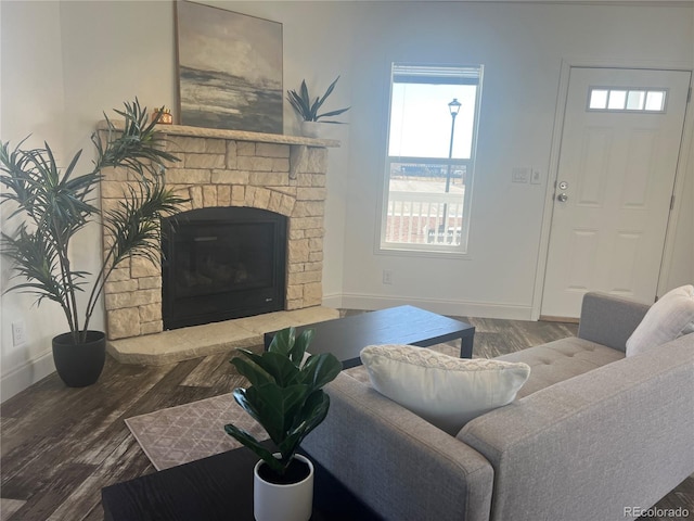 living room featuring hardwood / wood-style flooring and a stone fireplace