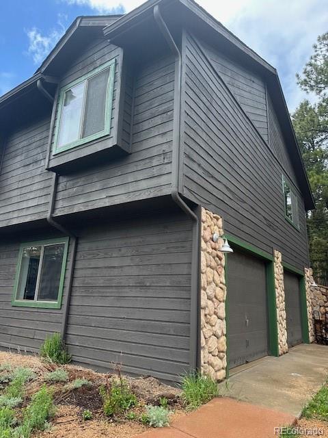4041 Trout Creed Rd, Woodland Park, CO 80863 - view of home's exterior featuring an attached garage and stone siding