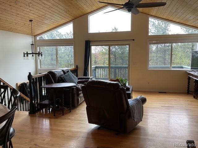 4041 Trout Creed Rd, Woodland Park, CO 80863 - living area with a ceiling fan, wood ceiling, light wood-style floors, high vaulted ceiling, and a chandelier