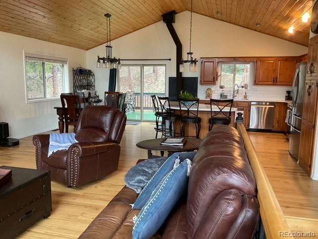 4041 Trout Creed Rd, Woodland Park, CO 80863 - living area with light wood-type flooring, a chandelier, healthy amount of natural light, high vaulted ceiling, and wood ceiling