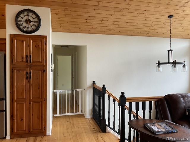 4041 Trout Creed Rd, Woodland Park, CO 80863 - hallway featuring an upstairs landing, light wood finished floors, vaulted ceiling, and wood ceiling