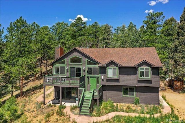 4041 Trout Creed Rd, Woodland Park, CO 80863 - view of front facade with a deck, stairs, a chimney, and a patio area