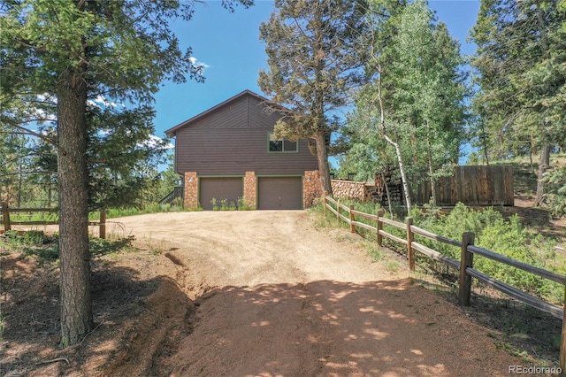 4041 Trout Creed Rd, Woodland Park, CO 80863 - view of side of home featuring an attached garage and dirt driveway