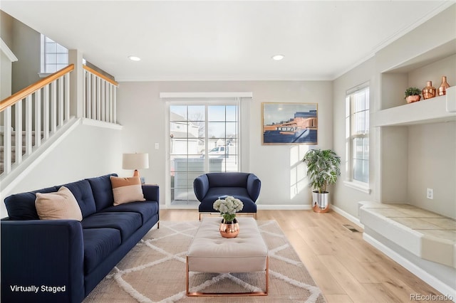 living room featuring crown molding and light wood-type flooring