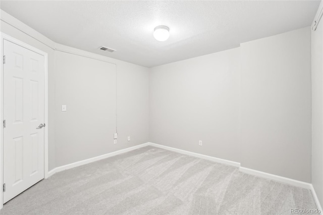 carpeted empty room featuring a textured ceiling