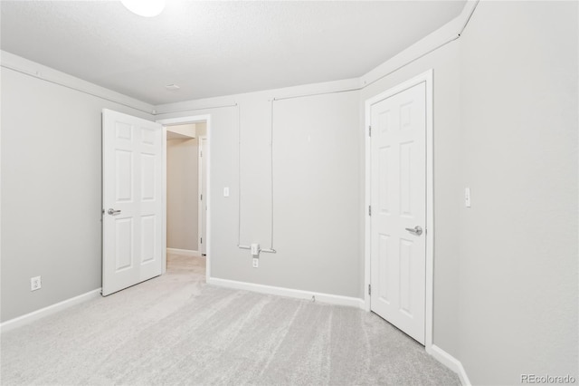 unfurnished bedroom with light colored carpet and a textured ceiling