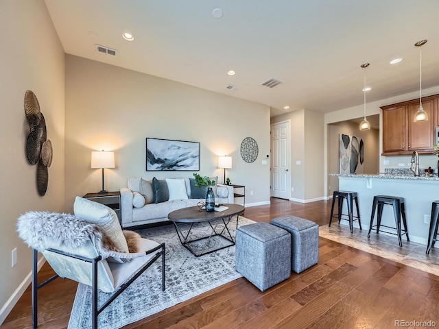 living area featuring dark wood-style floors, baseboards, and visible vents