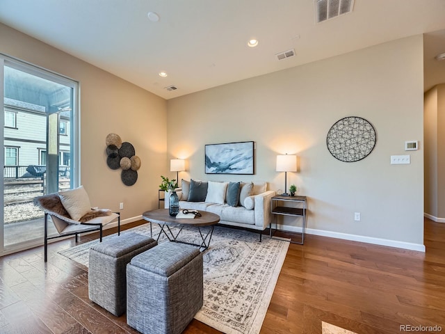 living room with baseboards, visible vents, wood finished floors, and recessed lighting