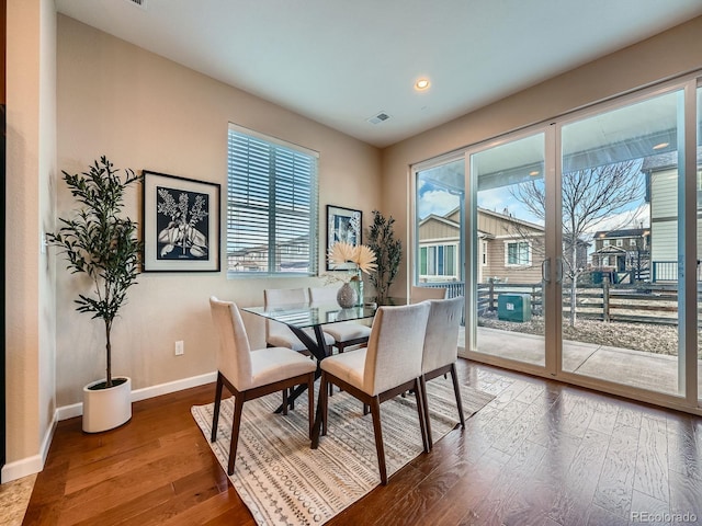 dining area featuring a wealth of natural light, baseboards, visible vents, and wood finished floors