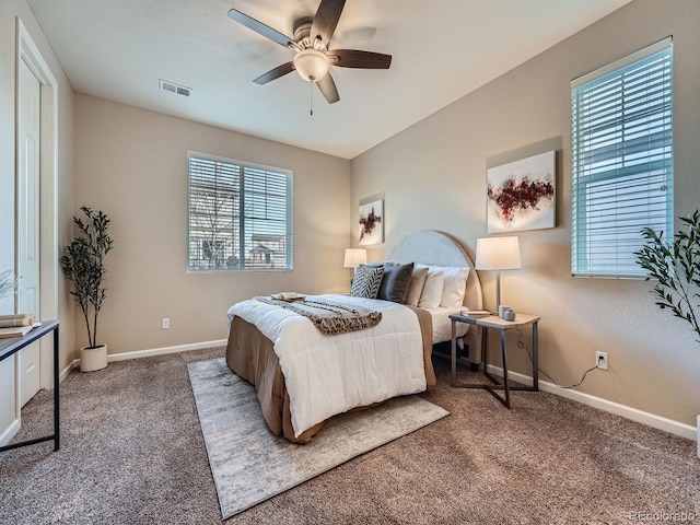 carpeted bedroom with baseboards, visible vents, and ceiling fan