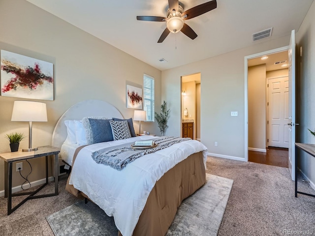 bedroom with baseboards, connected bathroom, visible vents, and carpet flooring