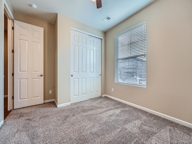 unfurnished bedroom featuring visible vents, baseboards, a ceiling fan, carpet flooring, and a closet