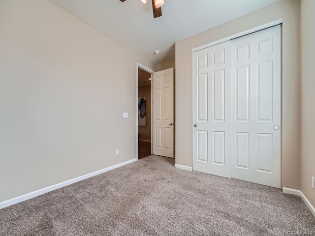 unfurnished bedroom featuring carpet, baseboards, ceiling fan, and a closet