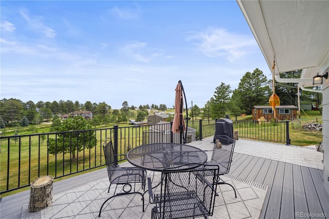 1233 Starling Ln, Elizabeth, CO 80107 - wooden terrace with outdoor dining area, a lawn, an outbuilding, and view of scattered trees