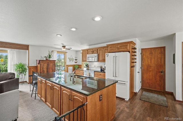 1233 Starling Ln, Elizabeth, CO 80107 - kitchen with white appliances, healthy amount of natural light, an island with sink, ceiling fan, and recessed lighting